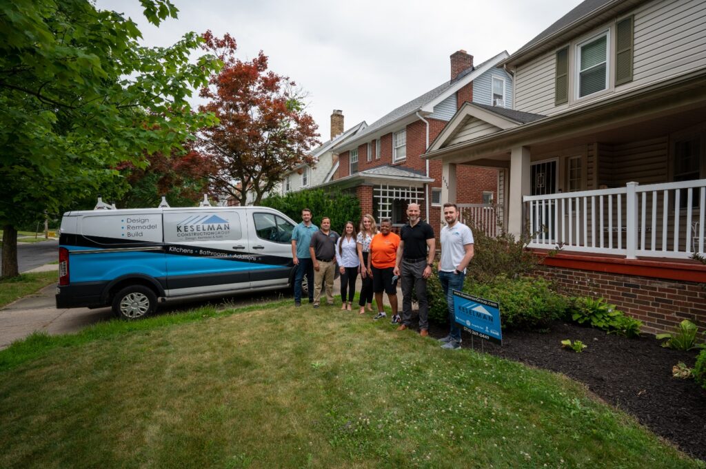 The team from Keselman Construction Group poses by their van with homeowners 