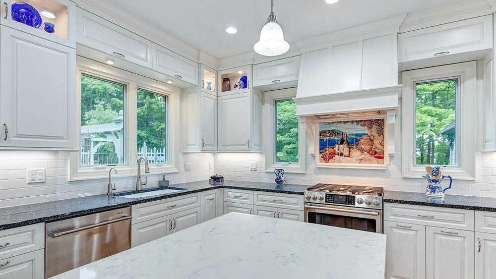 Cleveland kitchen remodeling project with Large white countertops island and surrounding counters
